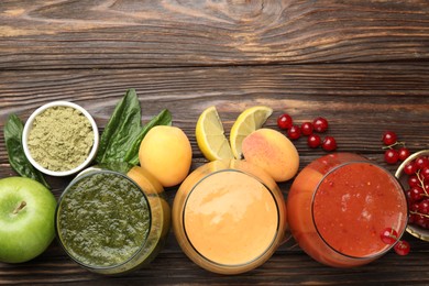 Photo of Superfood. Tasty smoothies in glasses and ingredients on wooden table, flat lay. Space for text