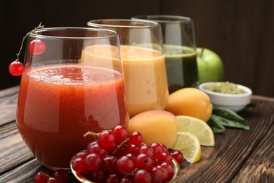 Photo of Superfood. Tasty smoothies in glasses and ingredients on wooden table, closeup