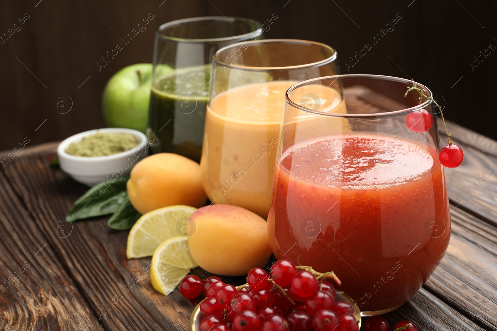 Superfood. Tasty smoothies in glasses and ingredients on wooden table, closeup Photo of Superfood. Tasty smoothies in glasses and ingredients on wooden table, closeup