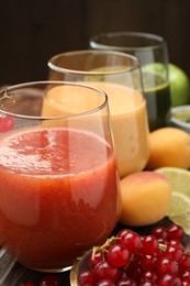 Photo of Superfood. Tasty smoothies in glasses and ingredients on table, closeup