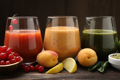 Photo of Superfood. Tasty smoothies in glasses and ingredients on wooden table, closeup