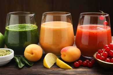 Photo of Superfood. Tasty smoothies in glasses and ingredients on wooden table, closeup
