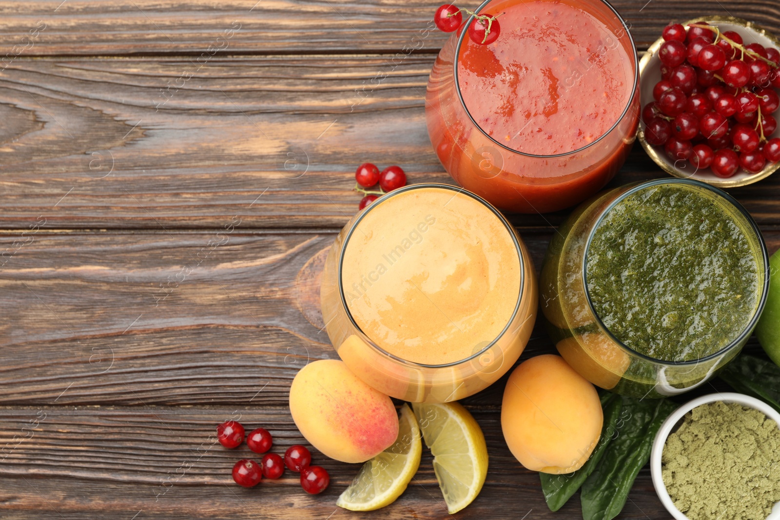 Superfood. Tasty smoothies in glasses and ingredients on wooden table, flat lay. Space for text Photo of Superfood. Tasty smoothies in glasses and ingredients on wooden table, flat lay. Space for text