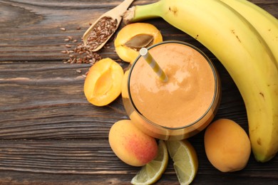 Photo of Superfood. Tasty smoothie in glass and ingredients on wooden table, flat lay. Space for text