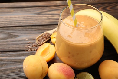 Photo of Superfood. Tasty smoothie in glass and ingredients on wooden table, closeup. Space for text