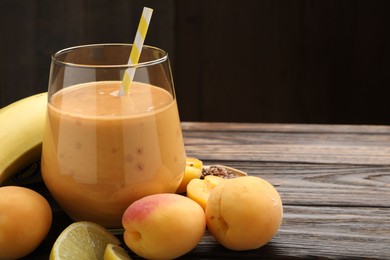 Photo of Superfood. Tasty smoothie in glass and ingredients on wooden table, closeup. Space for text