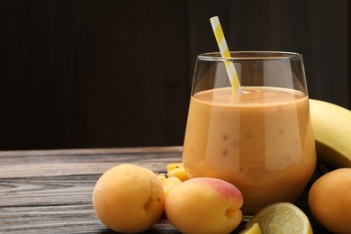 Photo of Superfood. Tasty smoothie in glass and ingredients on wooden table, closeup. Space for text