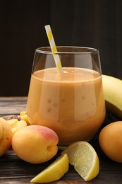 Photo of Superfood. Tasty smoothie in glass and ingredients on wooden table, closeup