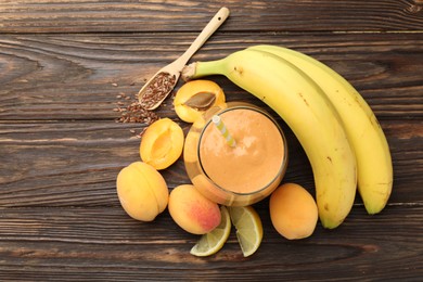 Photo of Superfood. Tasty smoothie in glass and ingredients on wooden table, flat lay. Space for text