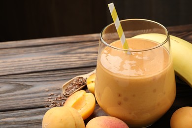 Photo of Superfood. Tasty smoothie in glass and ingredients on wooden table, closeup. Space for text