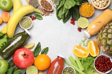 Photo of Superfood. Tasty smoothies in glass bottles and ingredients on light grey table, flat lay. Space for text