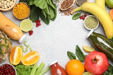 Photo of Superfood. Tasty smoothies in glass bottles and ingredients on light grey table, flat lay. Space for text