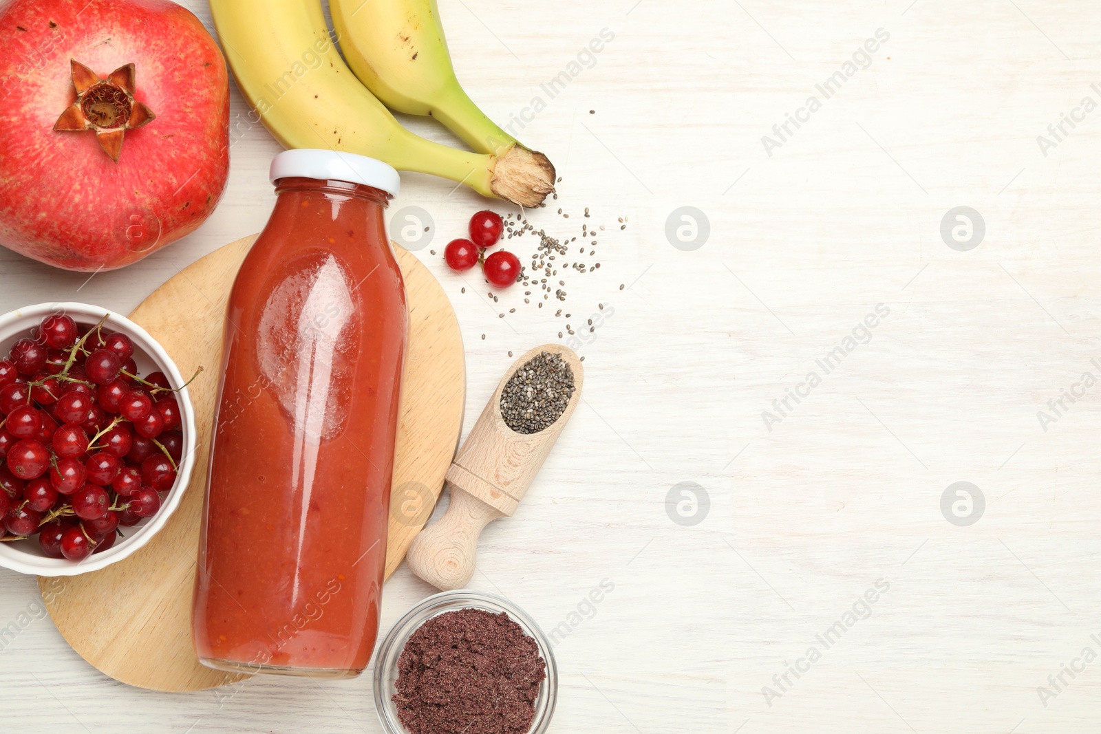 Superfood. Tasty smoothie in glass bottle and ingredients on light wooden table, flat lay. Space for text Photo of Superfood. Tasty smoothie in glass bottle and ingredients on light wooden table, flat lay. Space for text