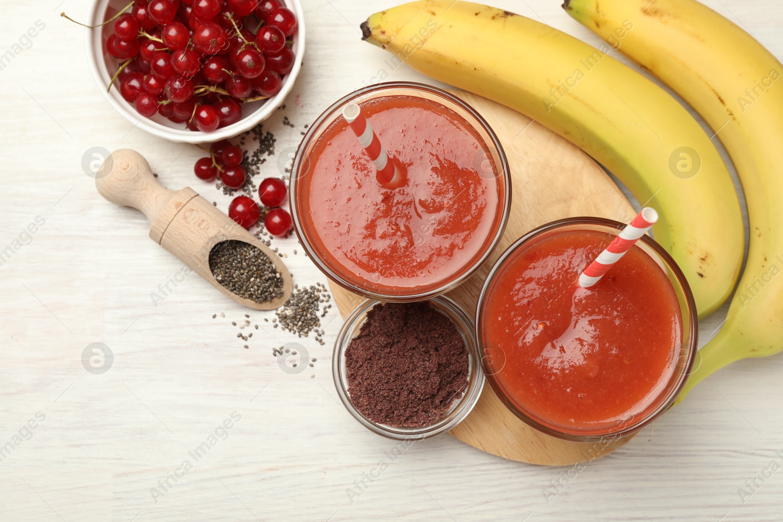 Superfood. Tasty smoothies in glasses and ingredients on light wooden table, flat lay. Space for text Photo of Superfood. Tasty smoothies in glasses and ingredients on light wooden table, flat lay. Space for text