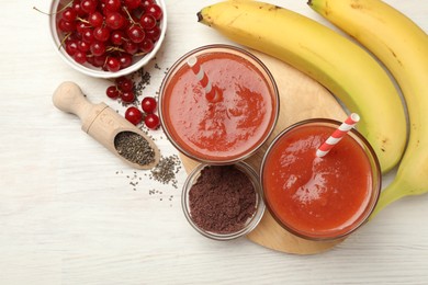 Photo of Superfood. Tasty smoothies in glasses and ingredients on light wooden table, flat lay. Space for text