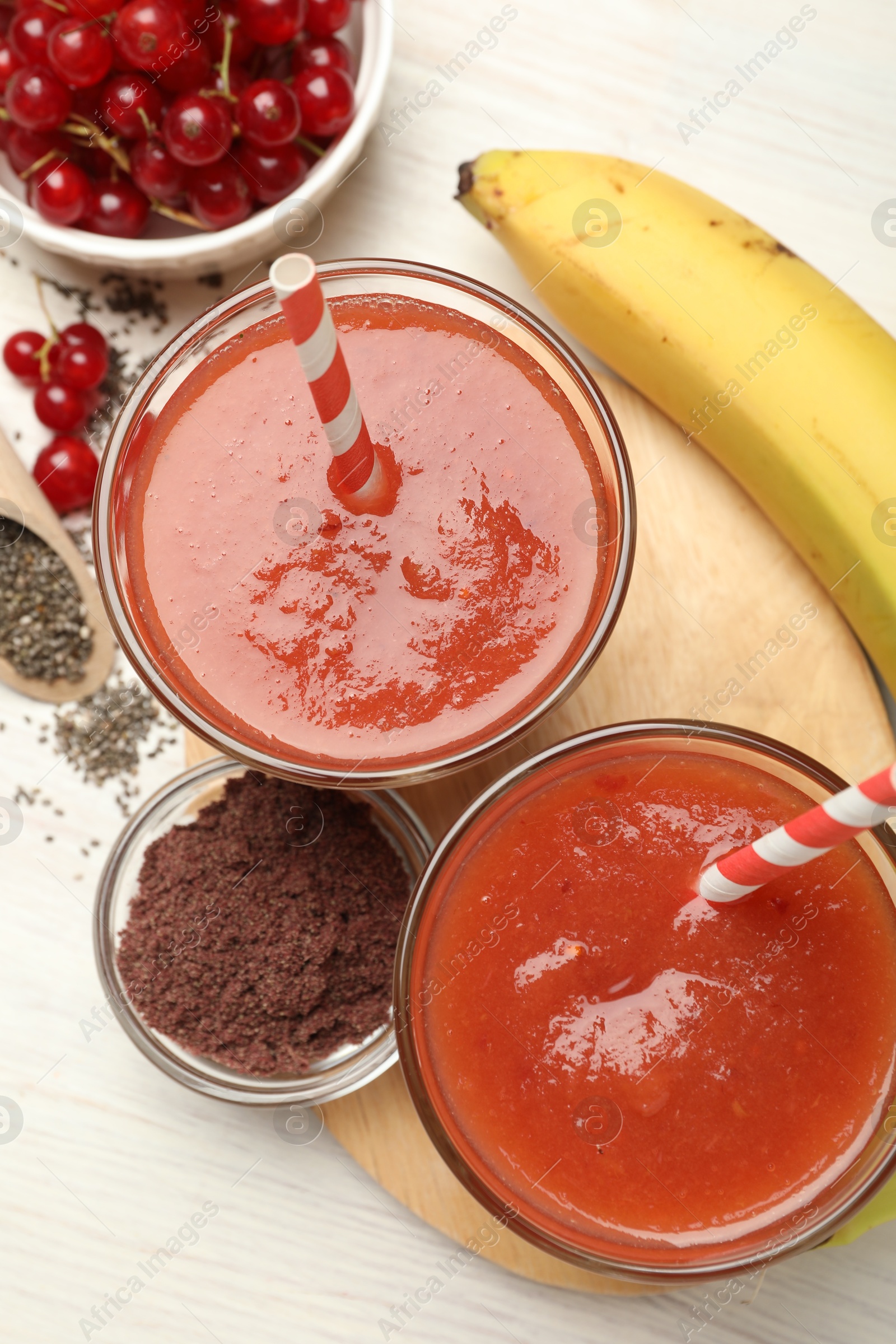 Superfood. Tasty smoothies in glasses and ingredients on light wooden table, flat lay Photo of Superfood. Tasty smoothies in glasses and ingredients on light wooden table, flat lay