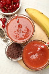 Photo of Superfood. Tasty smoothies in glasses and ingredients on light wooden table, flat lay