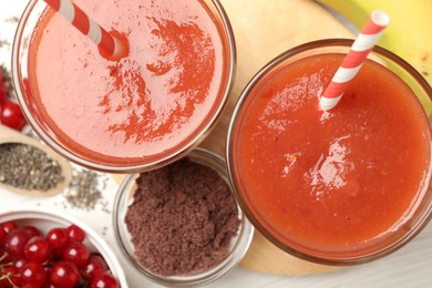 Photo of Superfood. Tasty smoothies in glasses and ingredients on table, flat lay