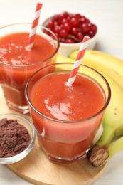 Photo of Superfood. Tasty smoothies in glasses and ingredients on table, closeup