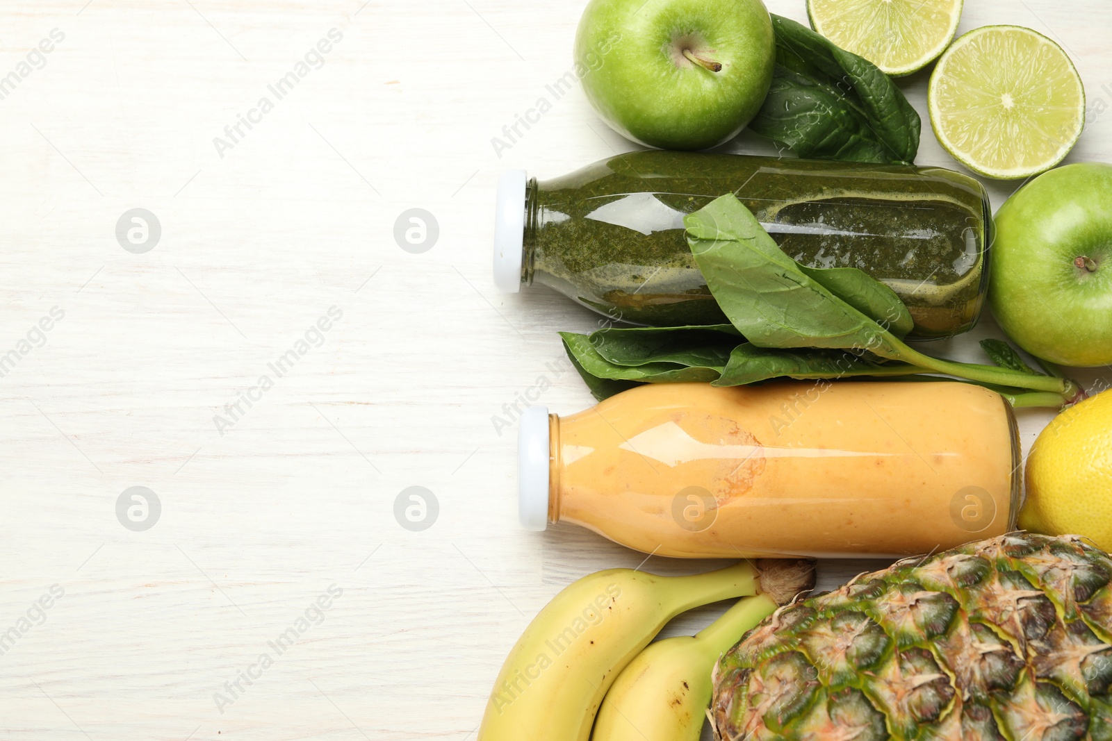 Superfood. Tasty smoothies in glass bottles and ingredients on light wooden table, flat lay. Space for text Photo of Superfood. Tasty smoothies in glass bottles and ingredients on light wooden table, flat lay. Space for text