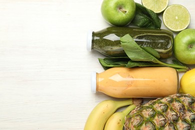 Photo of Superfood. Tasty smoothies in glass bottles and ingredients on light wooden table, flat lay. Space for text