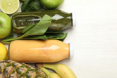 Photo of Superfood. Tasty smoothies in glass bottles and ingredients on light wooden table, flat lay. Space for text