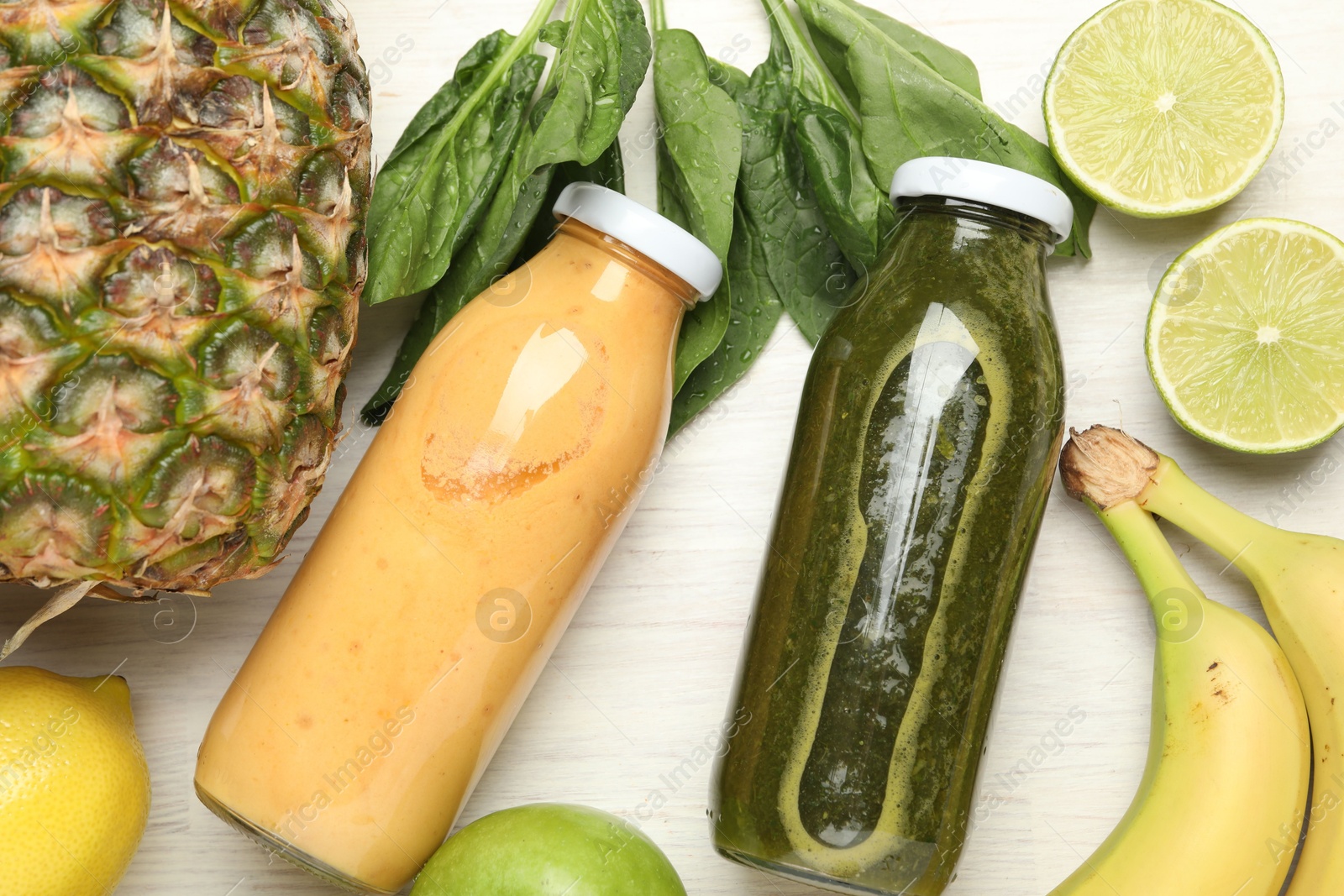 Superfood. Tasty smoothies in glass bottles and ingredients on light wooden table, flat lay Photo of Superfood. Tasty smoothies in glass bottles and ingredients on light wooden table, flat lay