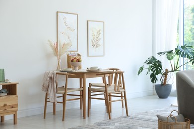 Photo of Beautiful table setting, chairs and decor in dining room. Interior design