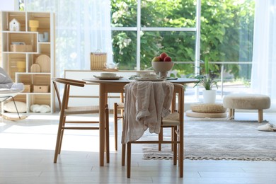 Photo of Beautiful table setting, chairs and decor in dining room. Interior design