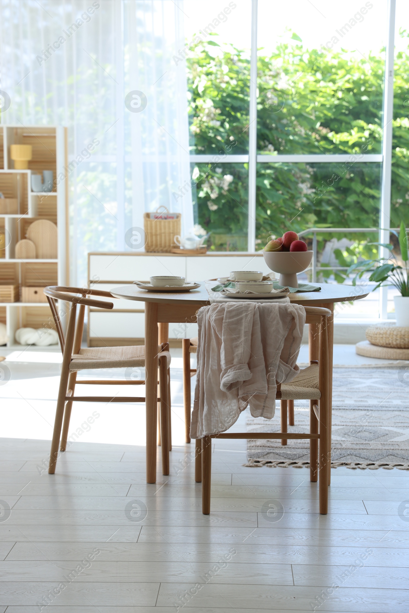 Photo of Beautiful table setting, chairs and decor in dining room. Interior design