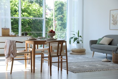 Photo of Stylish table setting, chairs and decor in dining room. Interior design
