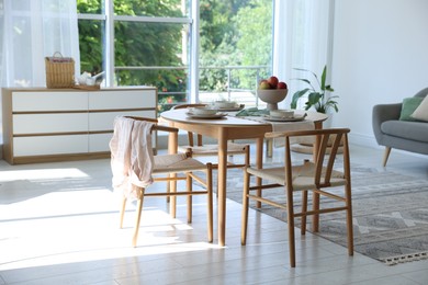 Photo of Stylish table setting, chairs and decor in dining room. Interior design