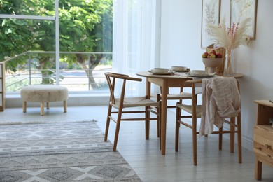 Photo of Stylish table setting, chairs and decor in dining room. Interior design