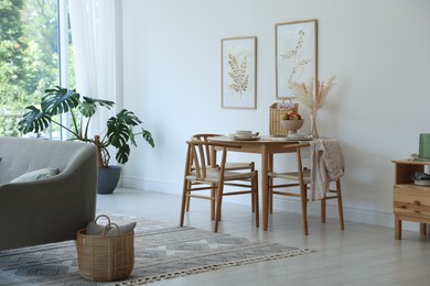 Photo of Stylish table setting, chairs, sofa and decor in dining room. Interior design