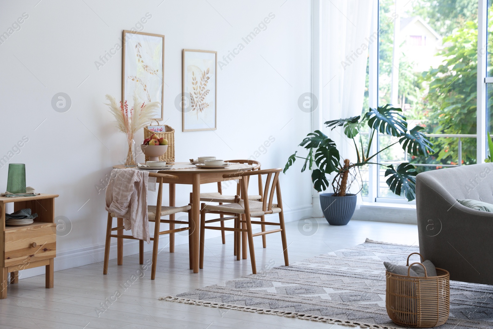 Photo of Stylish table setting, chairs, sofa and decor in dining room. Interior design