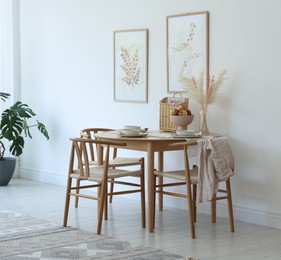 Photo of Stylish table setting, chairs, sofa and decor in dining room. Interior design