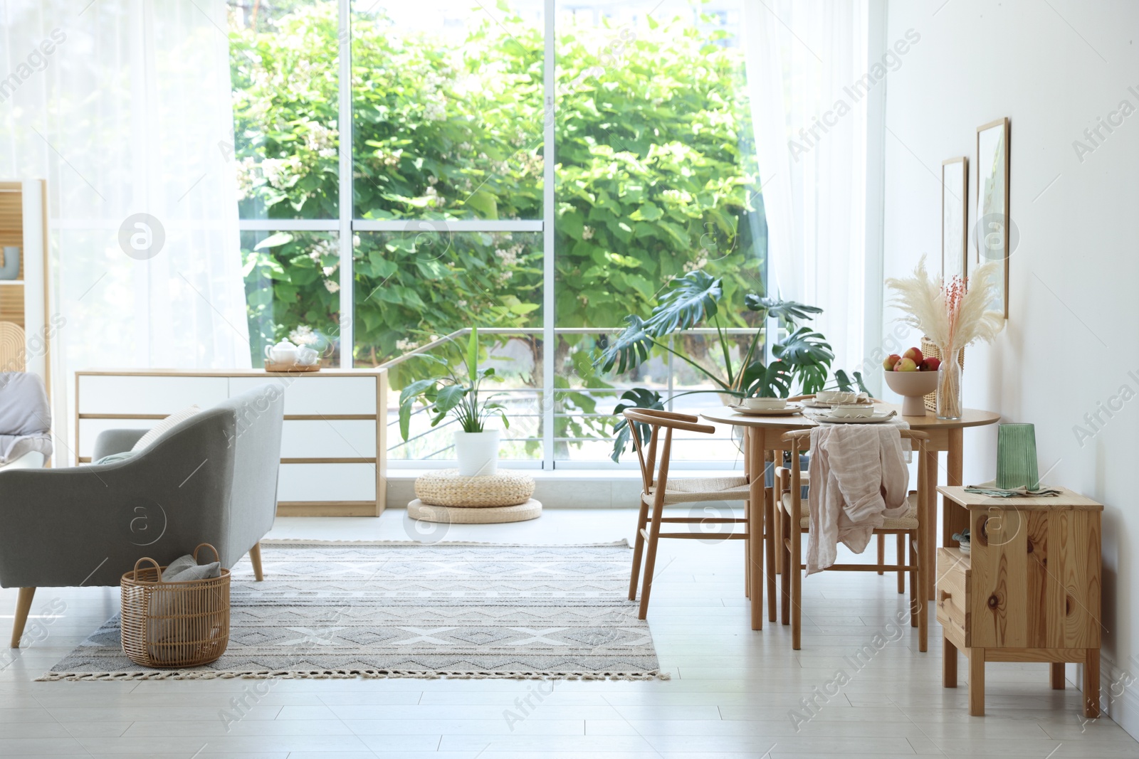 Photo of Stylish table setting, chairs, sofa and decor in dining room. Interior design