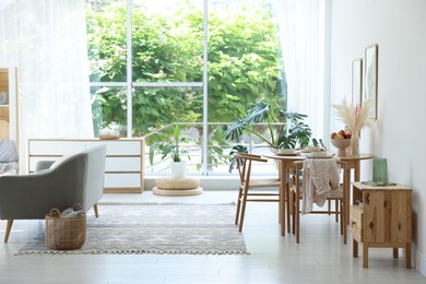 Photo of Stylish table setting, chairs, sofa and decor in dining room. Interior design