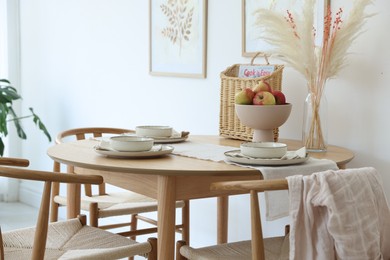Photo of Beautiful table setting, chairs and decor in dining room. Interior design