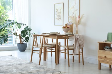 Photo of Beautiful table setting, chairs and decor in dining room. Interior design