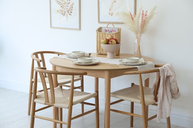 Photo of Beautiful table setting, chairs and decor in dining room. Interior design