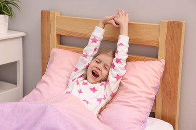 Photo of Little girl waking up in bed at home