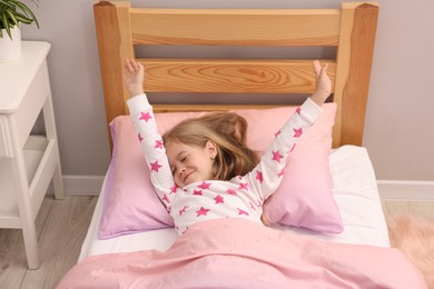 Photo of Little girl waking up in bed at home