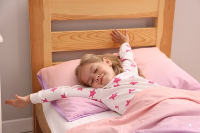 Photo of Little girl waking up in bed at home