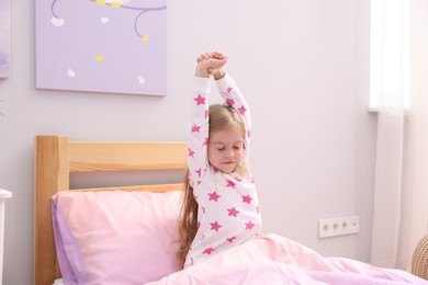 Photo of Little girl waking up in bed at home