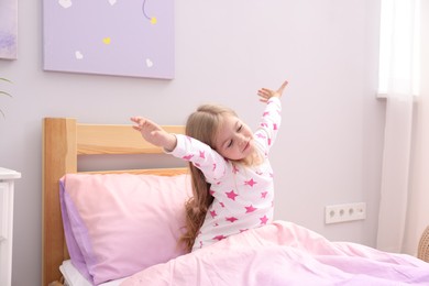 Photo of Little girl waking up in bed at home