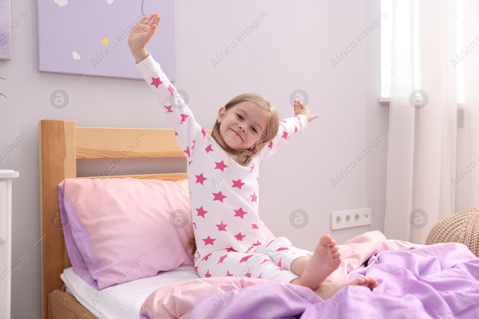 Little girl waking up in bed at home Photo of Little girl waking up in bed at home