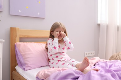 Photo of Little girl waking up in bed at home
