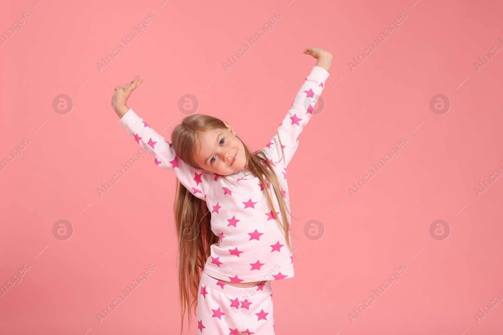Cute little girl in pajamas on pink background Photo of Cute little girl in pajamas on pink background