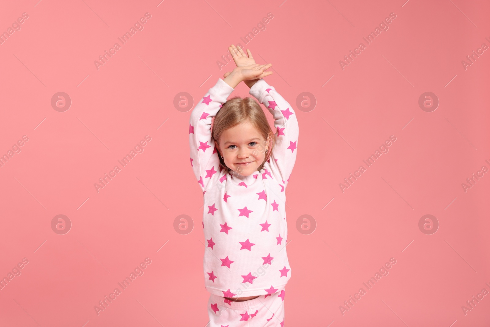 Cute little girl in pajamas on pink background Photo of Cute little girl in pajamas on pink background